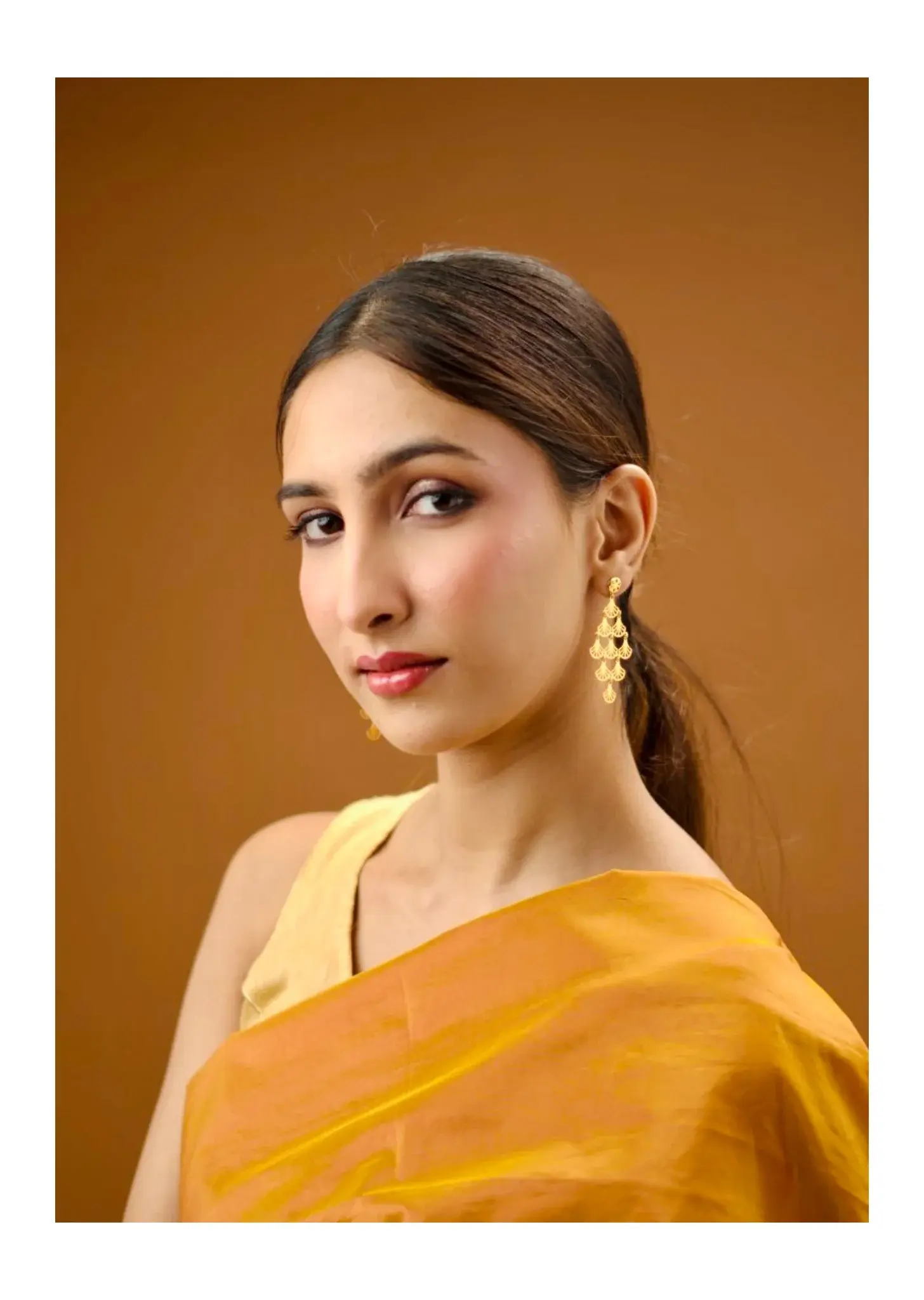 Portrait of a model in a yellow sari against ochre