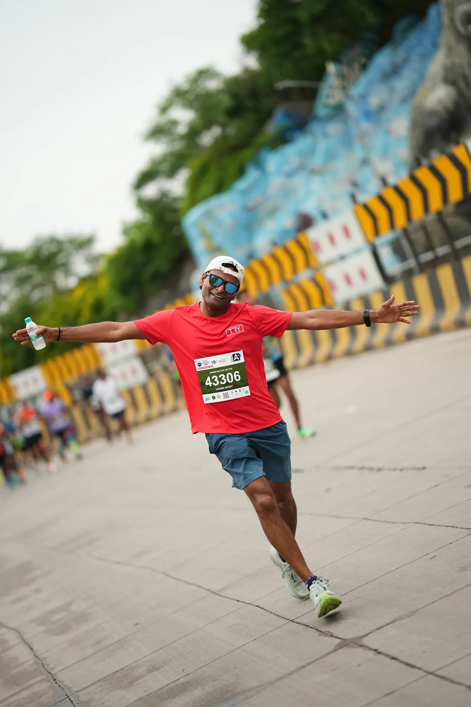 Runner in red opens his arms along the race route