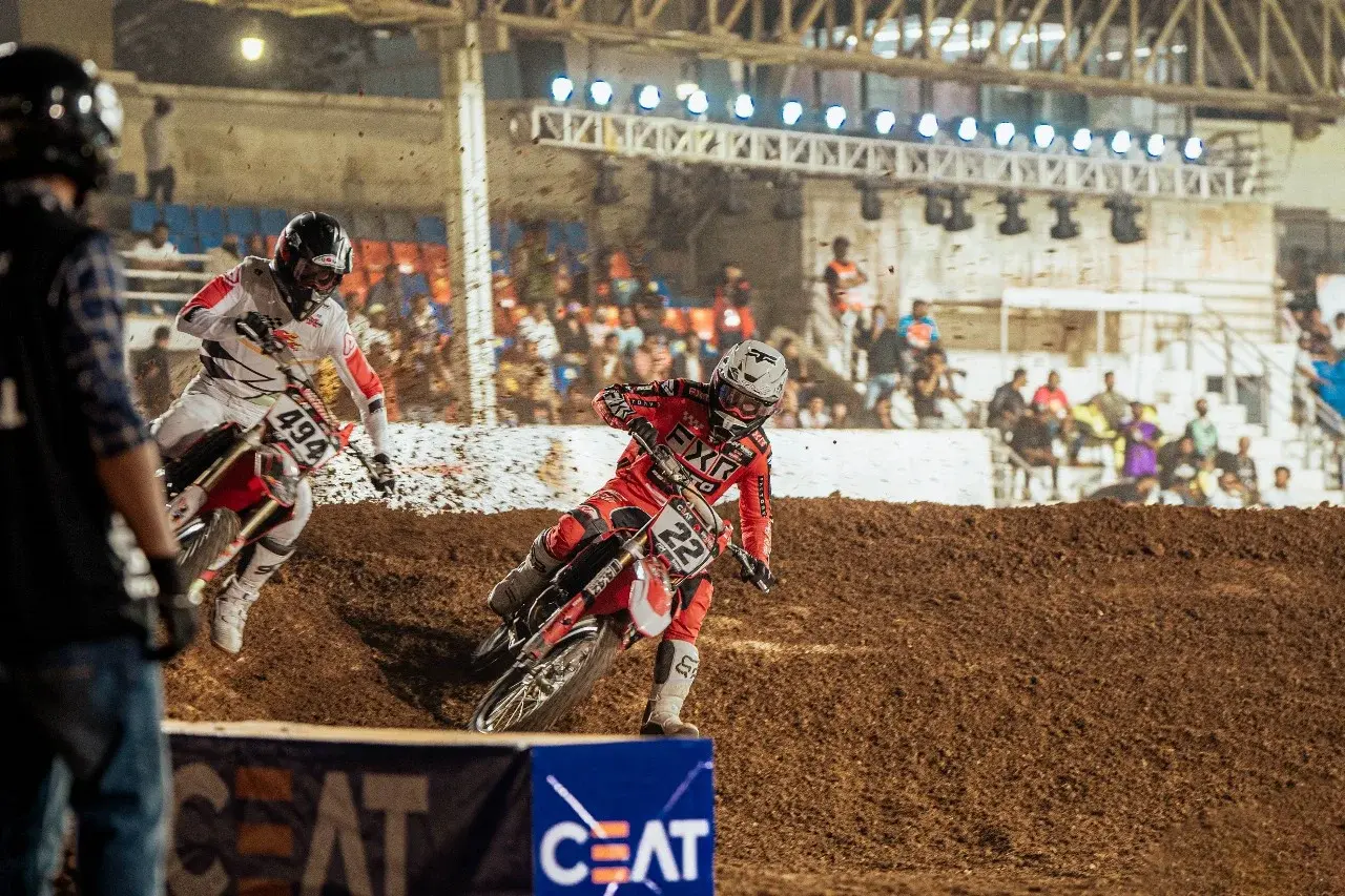 Motocross rider airborne in front of a packed grandstand